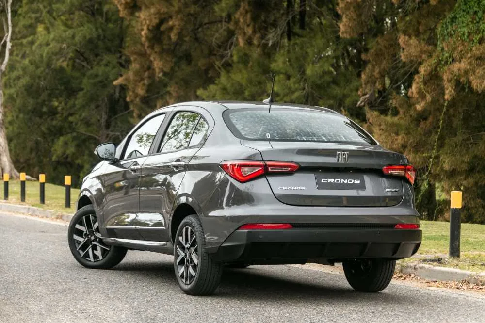 Fiat Cronos gris estacionado en una ruta arbolada